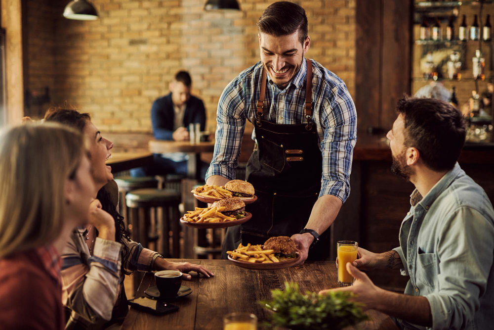 Garçom servindo amigos em restaurante