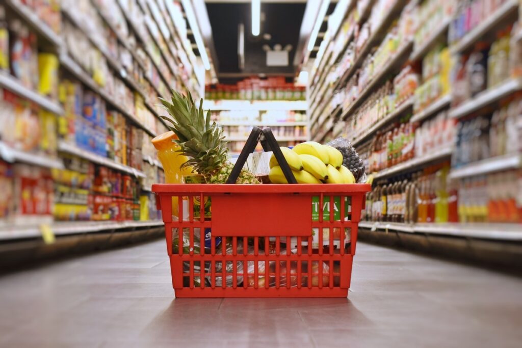 Cesta de compras em meio a um corredor de supermercado; setor domina o ranking da SBVC