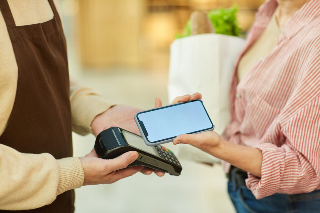 Mulher fazendo pagamento com NFC; orquestrador de pagamentos promete ajudar e-commerce