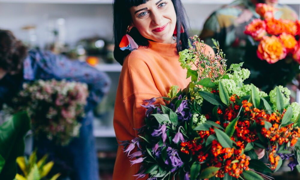 Mulher com flores em floricultura; Giuliana Flores indicada a prêmio