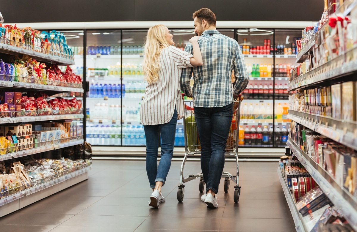 casal de homem e mulher fazendo compras em supermercado; festas de fim de ano