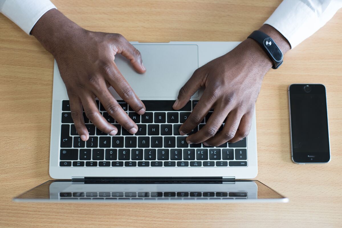 Vistas de cima, mãos de homem negro em McBook