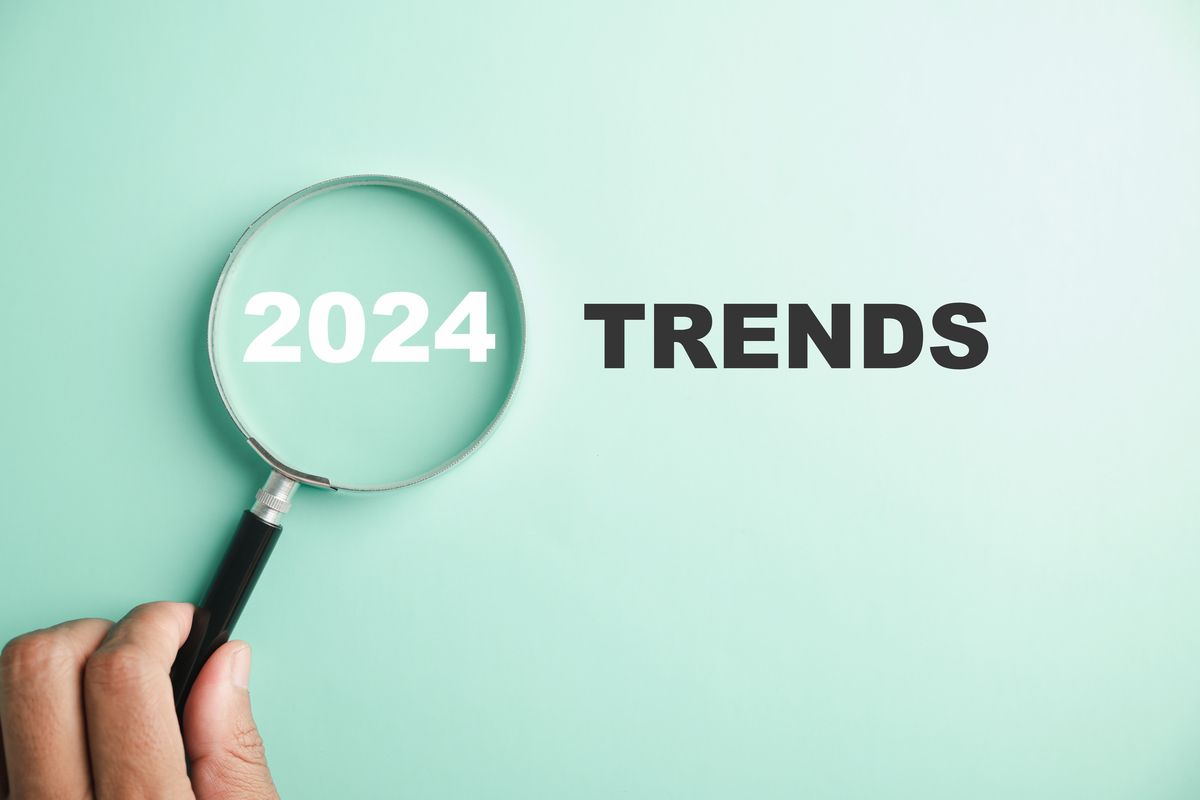Fundo verde claro escrito "2024 Trends" com uma lupa em cima do 2024