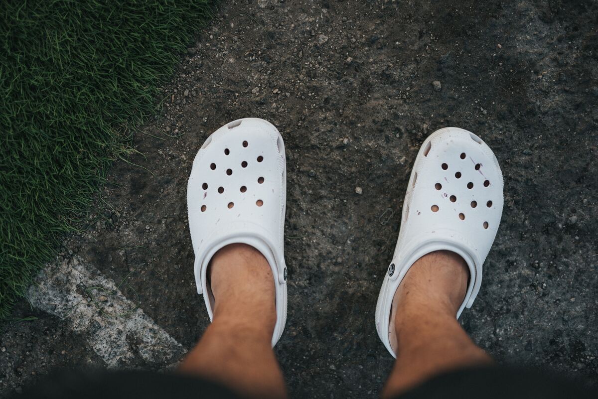 De cima pra baixo, homem tira foto dos seus pés de Crocs