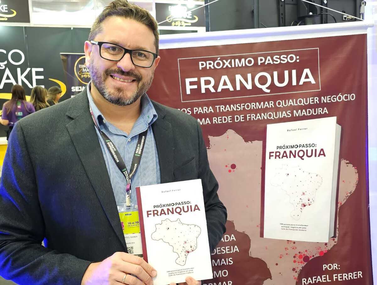 Rafael Ferrer segurando seu livr, "Próximo PAsso: FRANQUIA"