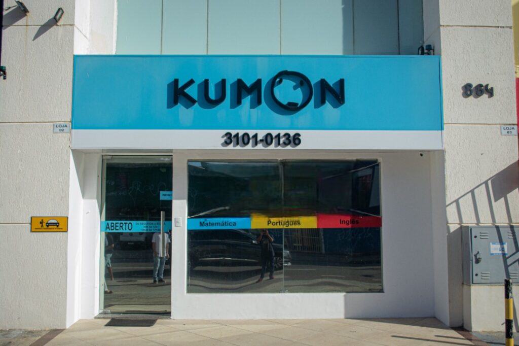 Fachada com logo azul do Kumon, com carinha no lugar do "O". 