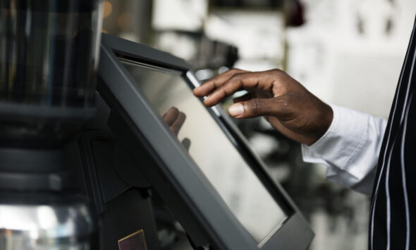 Close em pessoa fazendo self-checkout em tela