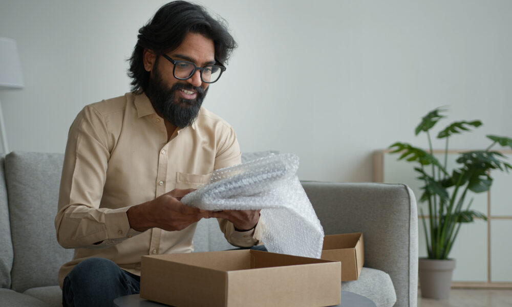 homem feliz abrindo caixa de serviço de assinatura; customer success