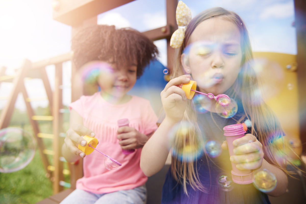 duas meninas brincando com bolha de sabão