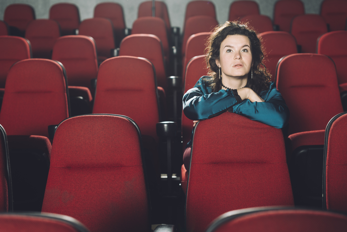 mulher sozinha no cinema; setor de serviços