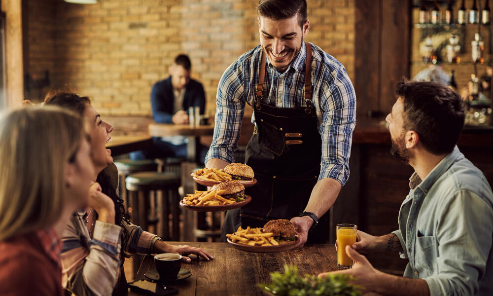 Garçom servindo amigos em restaurante