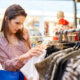 Mulher escolhendo blusas em loja de roupas