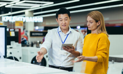 Vendedor com tablet na mão apresentando produtos para cliente