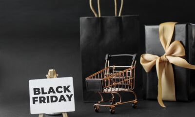 Sacola preta, carrinho de supermercado em miniatura e placa escrito "black friday"
