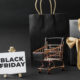 Sacola preta, carrinho de supermercado em miniatura e placa escrito "black friday"