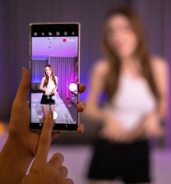 Jovens gravando vídeo de dança em celular; TikTok Shop é lançado nos EUA; Swarovski