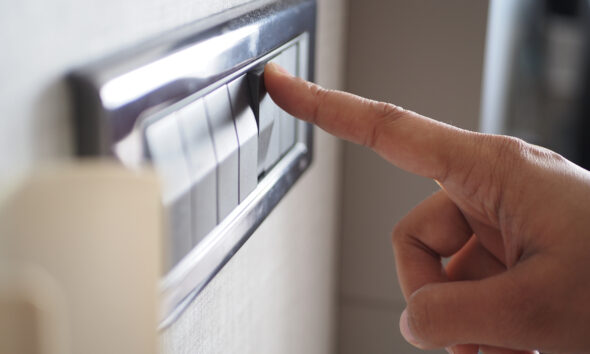 Mão com dedo indicador esticado para acender a luz no interruptor
