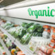 Área orgânica do supermercado, com legumes e frutas, e letreiro, em verde, escrito "Organic"