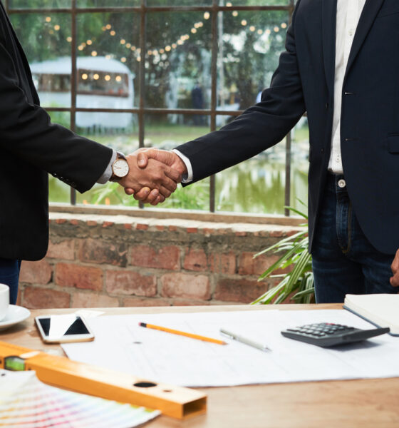 Parceiros de negócios apertando as mãos após reunião bem sucedida