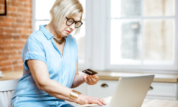 Mulher faz compras online com cartão; AliExpress entra em programa do governo