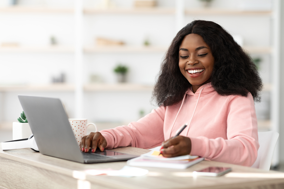 Mulher negra estudando em casa; edtech usa IA para ajudar alunos