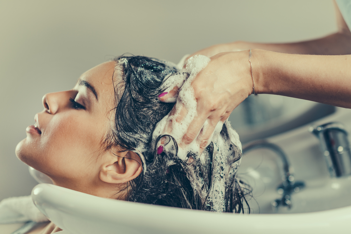 Mulher tendo cabelo lavado em salão de beleza