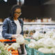 Mulher negra comprando repolho no supermercado