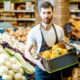Trabalhador de supermercado segurando caixa com legumes; Ranking IBEVAR-FIA mostra crescimento do setor