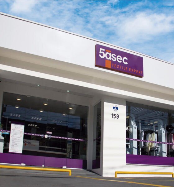 Fachada de loja do Grupo 5àsec, empresa de limpeza e conservação, é branca com detalhes em roxo