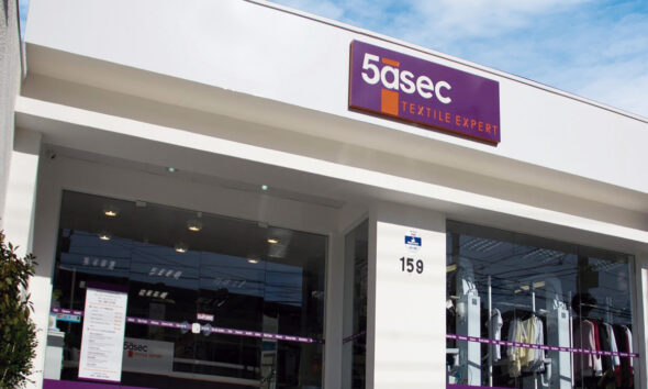 Fachada de loja do Grupo 5àsec, empresa de limpeza e conservação, é branca com detalhes em roxo