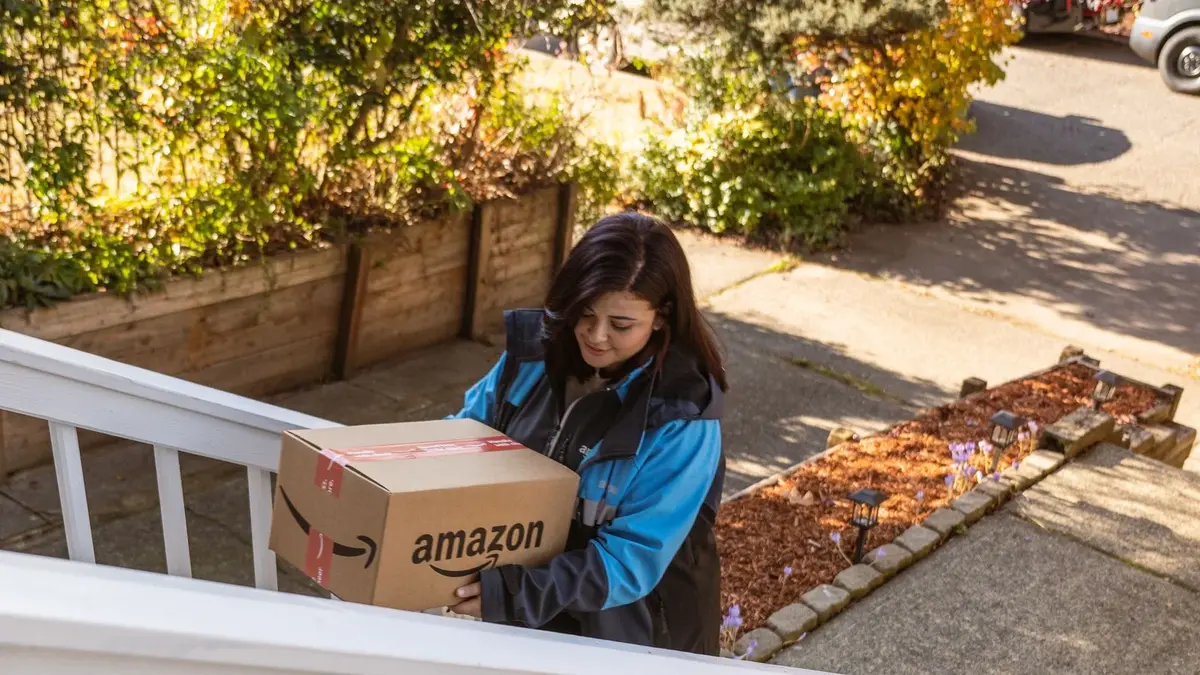 Entregadora da Amazon com uma caixa com a logo da empresa; Prime Day fez sucesso