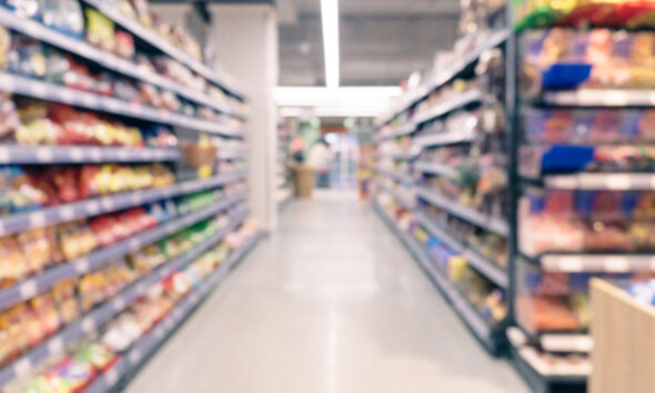 Corredor de supermercado desfocado abstrato com prateleiras coloridas e clientes irreconhecíveis como pano de fundo; setor de supermercados
