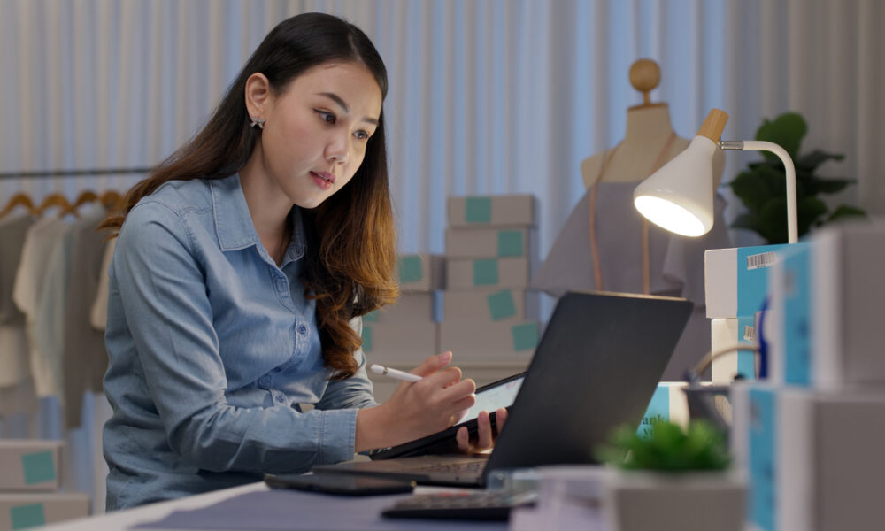 jovem asiática trabalhando com vendas no computador; conceito de omnicanalidade