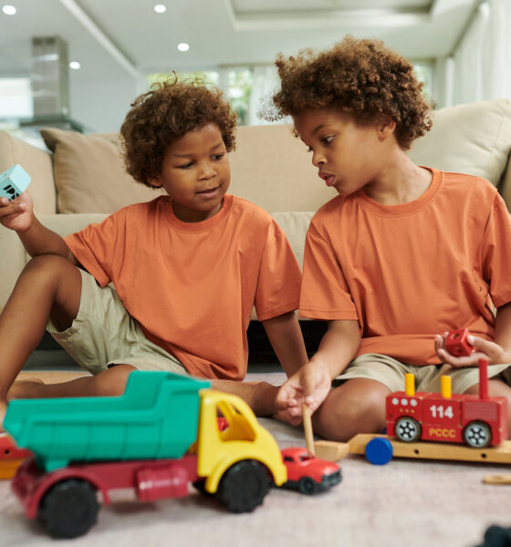 Crianças alegres brincando com brinquedos no chão da sala de estar no dia das crianças 2025 pix