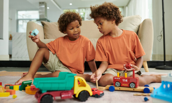 Crianças alegres brincando com brinquedos no chão da sala de estar no dia das crianças 2025 pix