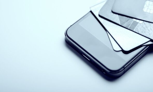 Pilha de cartões de crédito em cima de celular; cartão de crédito; click to pay; visa