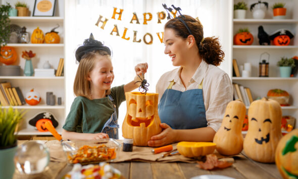 Feliz Halloween, mãe e filha esculpindo abóbora. Família se preparando para férias; consumo
