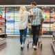 casal de homem e mulher fazendo compras em supermercado; festas de fim de ano