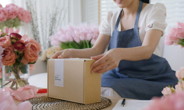 Mulher dona de pequena empresa embalando produto; pós-venda; prospecção