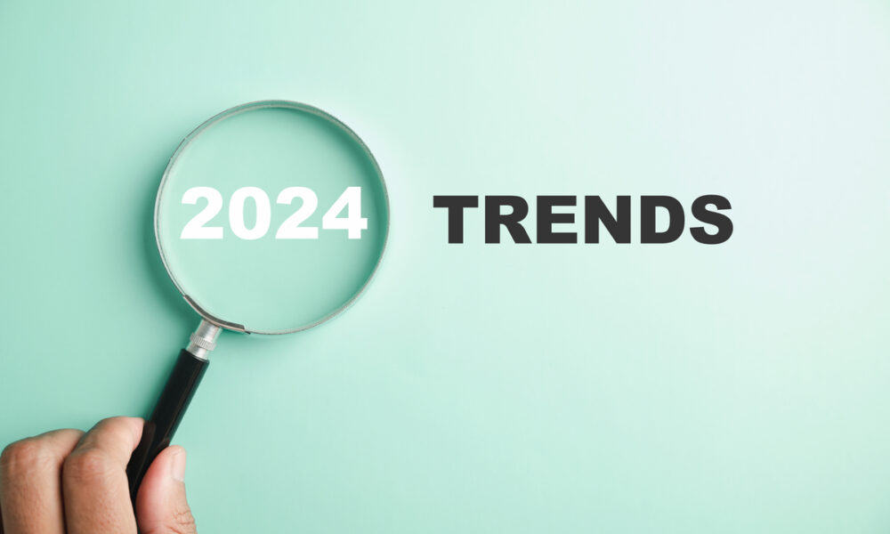 Fundo verde claro escrito "2024 Trends" com uma lupa em cima do 2024