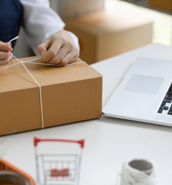 Pessoa amarrando uma caixa de entrega de produto; e-commerce brasileiro; e-commerces asiáticos