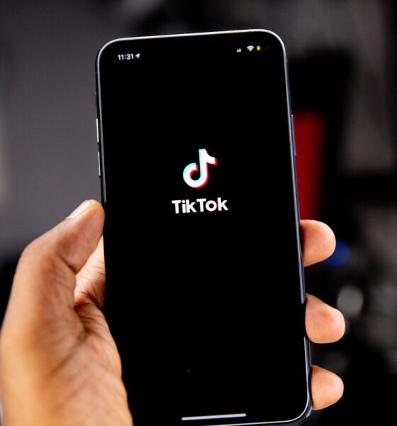 Pessoa segurando celular com aplicativo do TikTok sendo aberto
