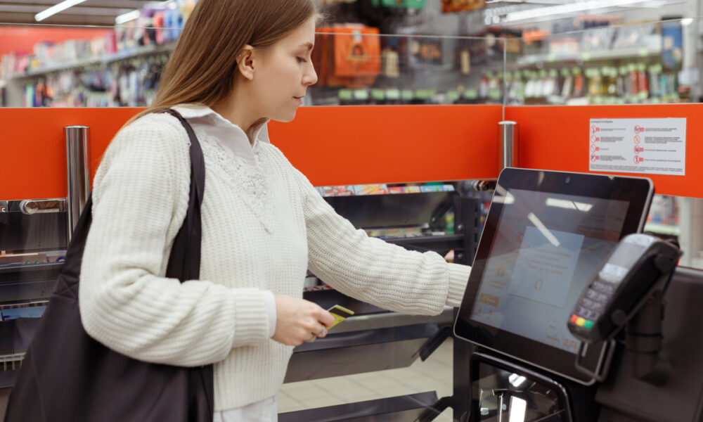 Mulher em totem de autoatendimento de supermercado; Walmart e outras empresas estão reavaliando o uso de tecnologia