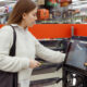 Mulher em totem de autoatendimento de supermercado; Walmart e outras empresas estão reavaliando o uso de tecnologia