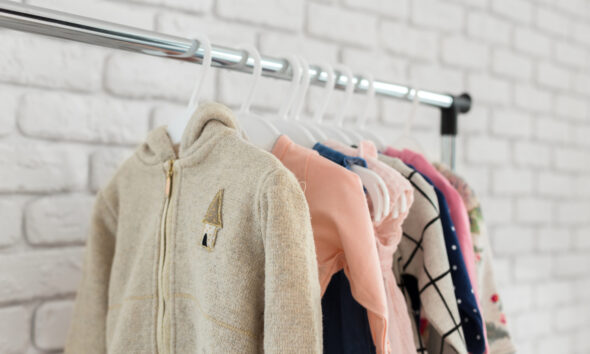 Arara com roupas infantis usadas para venda, como é feito na Cresci e Perdi, comprada pela Enjoei