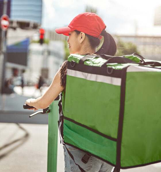 Mulher fazendo entrega de delivery; plataformas de entrega