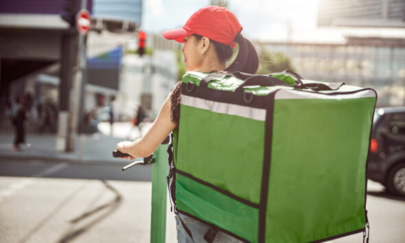 Mulher fazendo entrega de delivery; plataformas de entrega