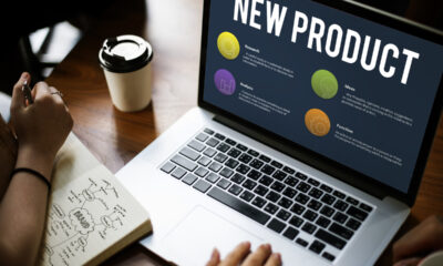 Laptop aberto com a frase "New Product" e bolas coloridas. Marketing