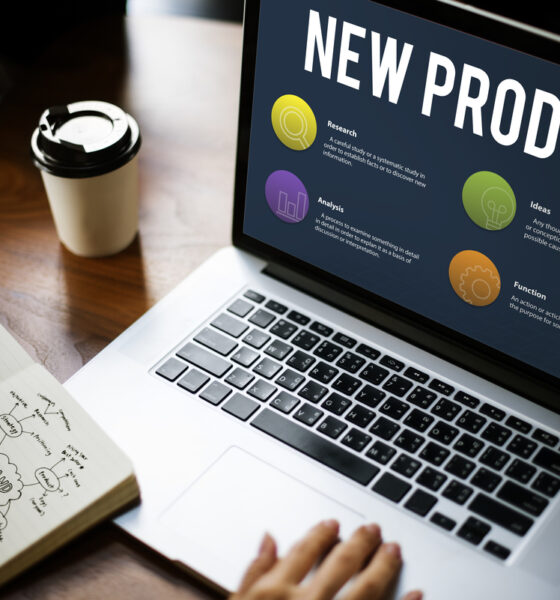 Laptop aberto com a frase "New Product" e bolas coloridas. Marketing