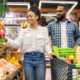 Casal de homem e mulher de pele negra fazendo compras; supermercados